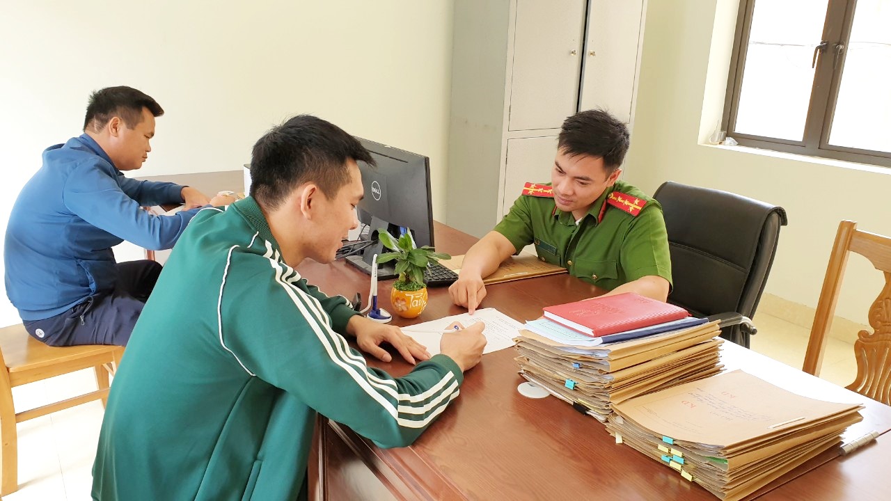 Cán bộ Đội QLHC về TTXH (Công an huyện Vân Đồn) hướng dẫn công dân thực hiện thủ tục.