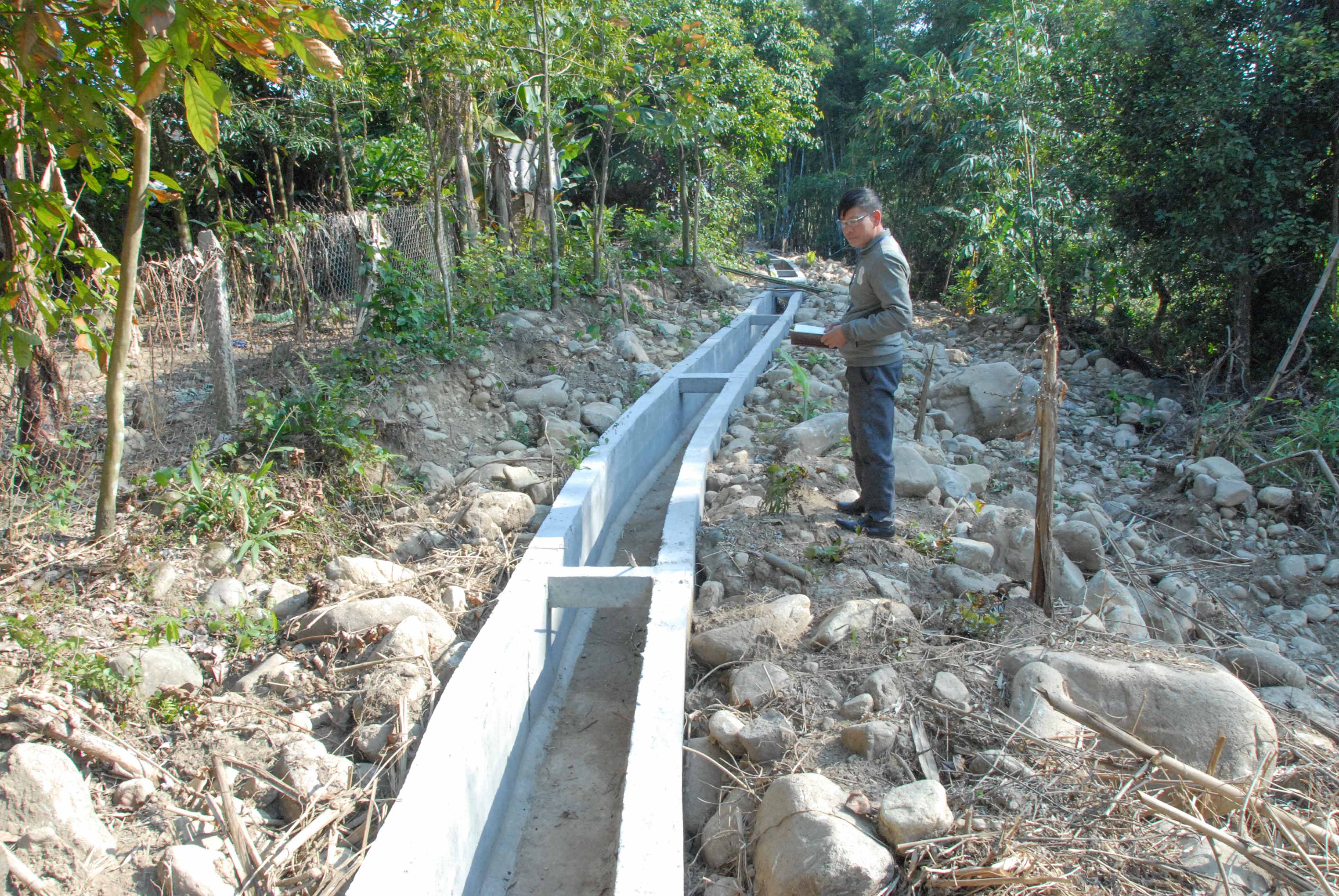 Cán bộ xã Quảng Sơn (huyện Hải Hà) giám sát chất lượng mương dẫn nước tưới tiêu sau thi công.