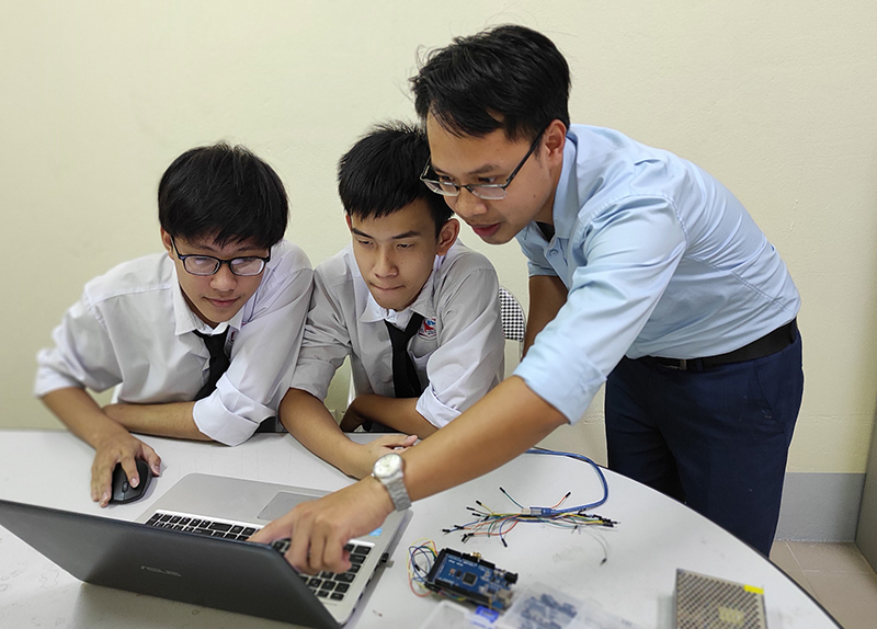 Thầy và trò Trường THPT Chuyên Hạ Long trao đổi về dự án lắp ráp robot.