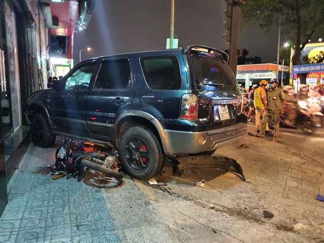 Chiếc xe máy nằm dưới gầm xe ô tô bị hư hỏng nặng