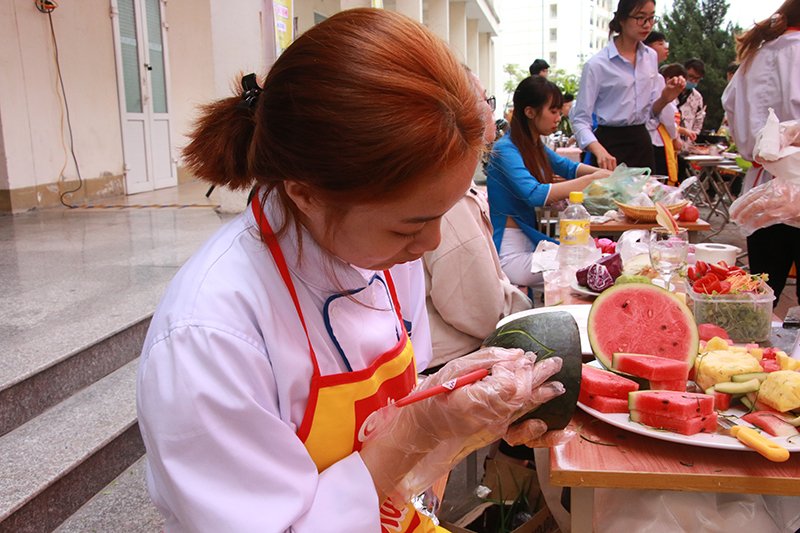 Các bạn sinh viên thể hiện sự khéo léo trong kỹ thuật cắt tỉa hoa quả trang trí món ăn.