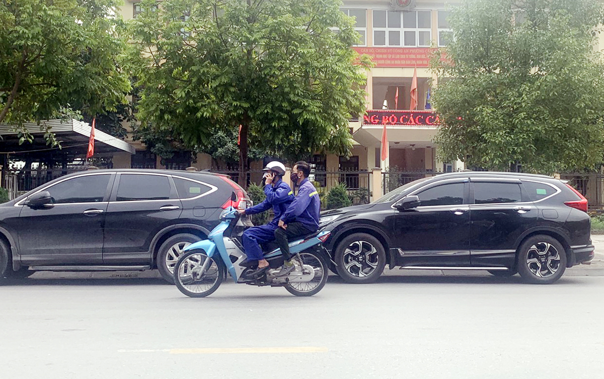Còn nhiều người dân điều khiển xe mô tô còn sử dụng điện thoại. 