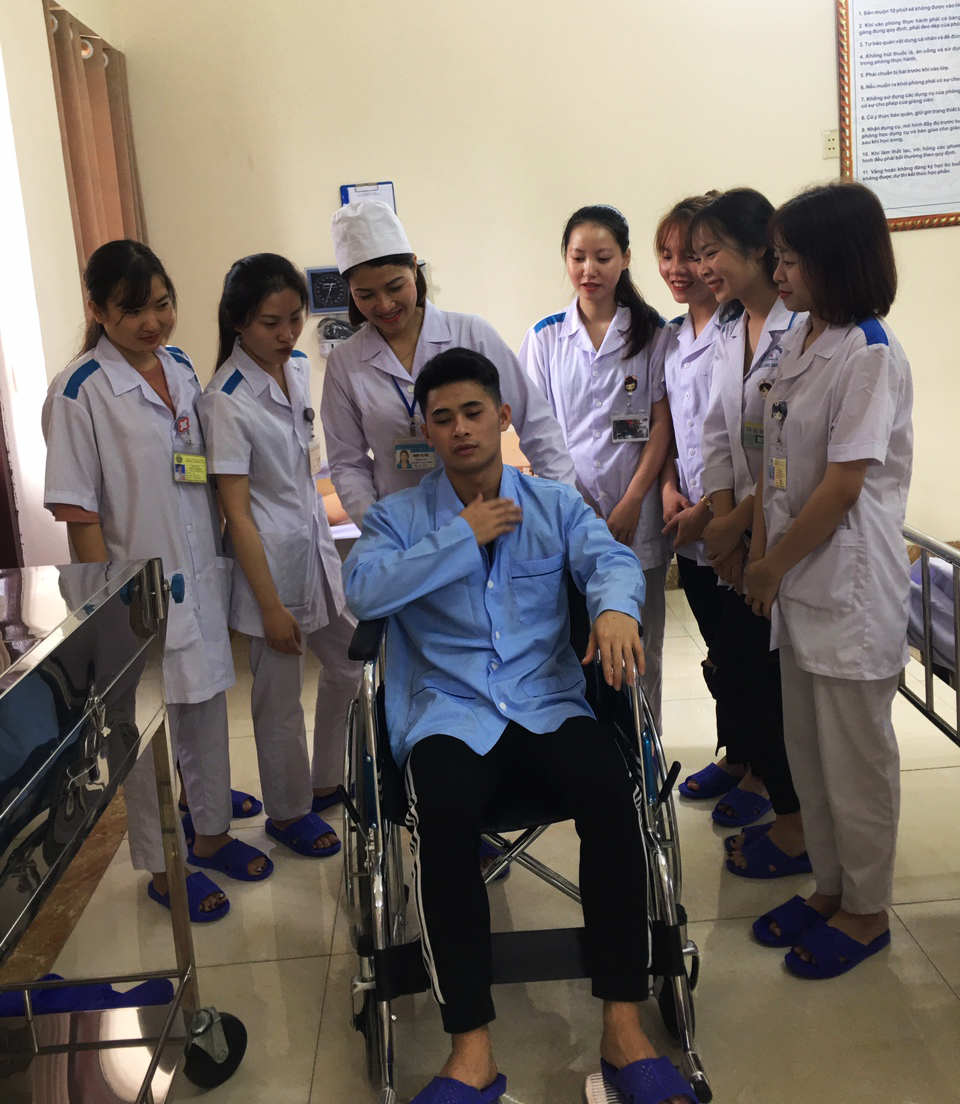 Giảng viên Đinh Thị Thu hướng dẫn sinh viên chăm sóc bệnh nhân.