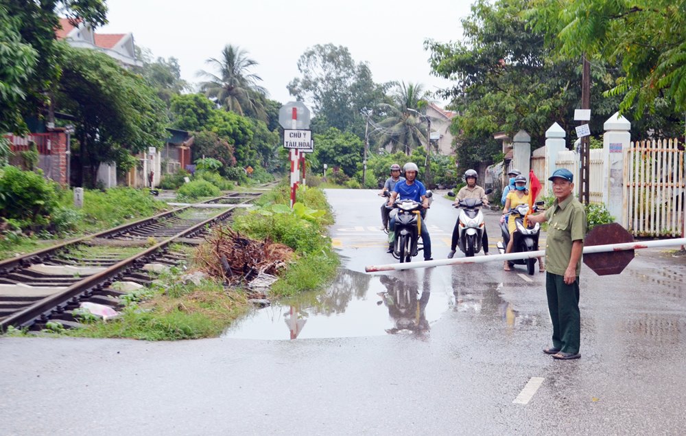 Thời gian tàu chạy qua, CCB Đỗ Bá Phiến lại hạ gác chắn tại điểm giao cắt tuyến đường sắt với đường dân sinh tại khu dân cư Tre Mai, phường Nam Khê (TP Uông Bí) đảm bảo an toàn cho người dân.