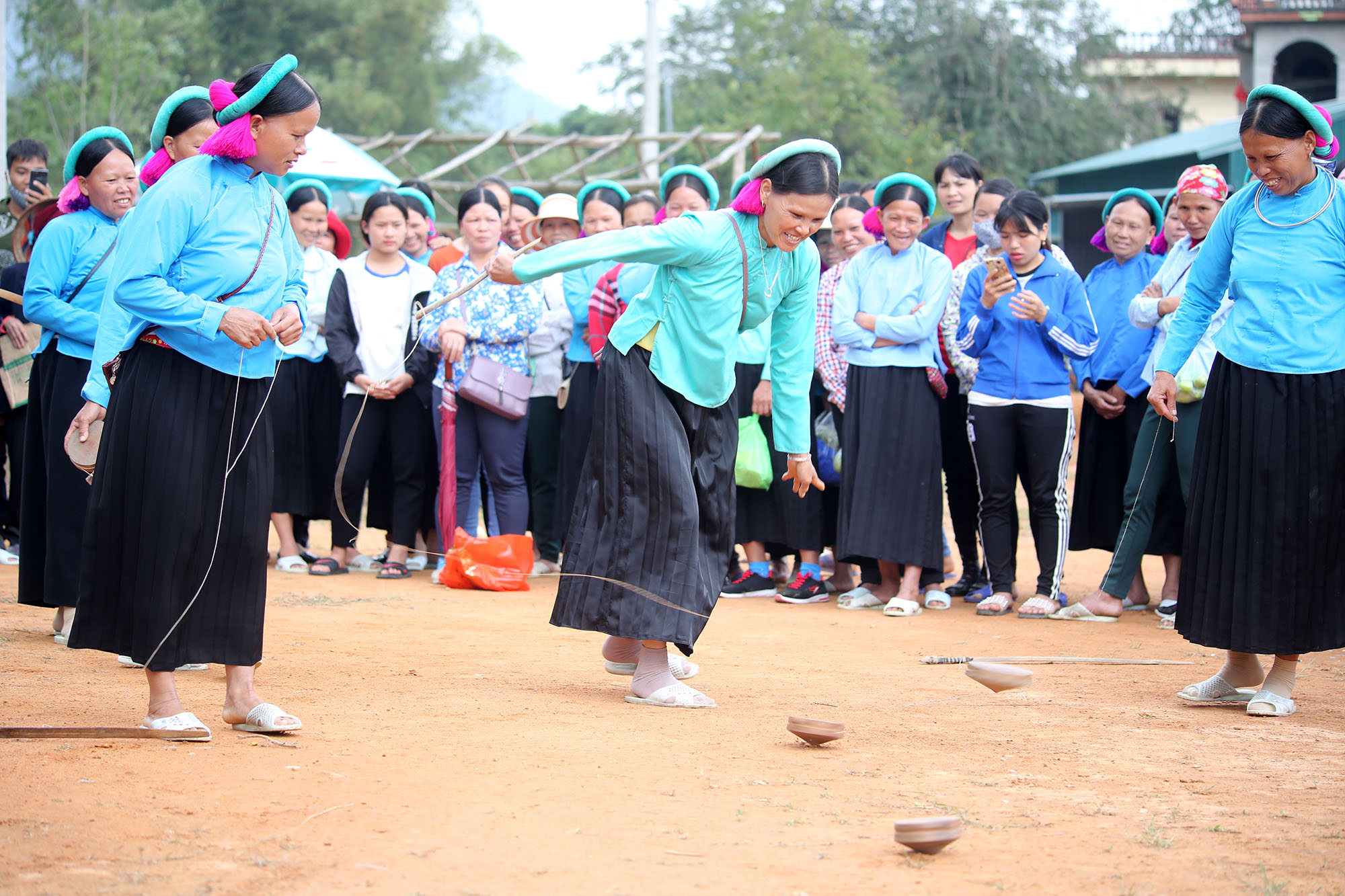 Chị em phụ nữ Sán Chỉ thi đánh quay tại lễ hội đình Lục Nà (huyện Bình Liêu) năm 2019.