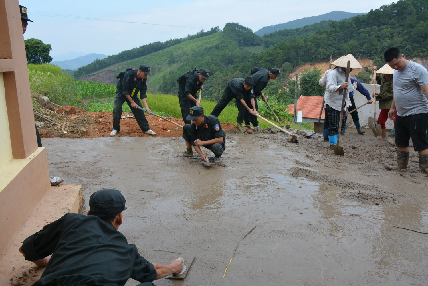 Chiến sĩ CSCĐ hỗ trợ nhân dân thi công sân nhà văn hóa thôn Kéo Kai, xã Đại Dực, huyện Tiên Yên.