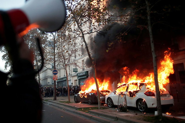 Những người biểu tình quá khích đốt phá xe hơi trên đường phố Paris ngày 28/1. Ảnh: EPA