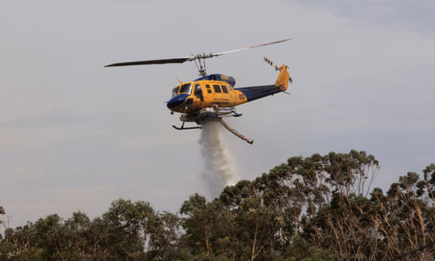 Máy bay trực thăng ném bom nước vào một đám cháy rừng tại Northmead, Sydney ngày 29/11. (Ảnh: Getty)