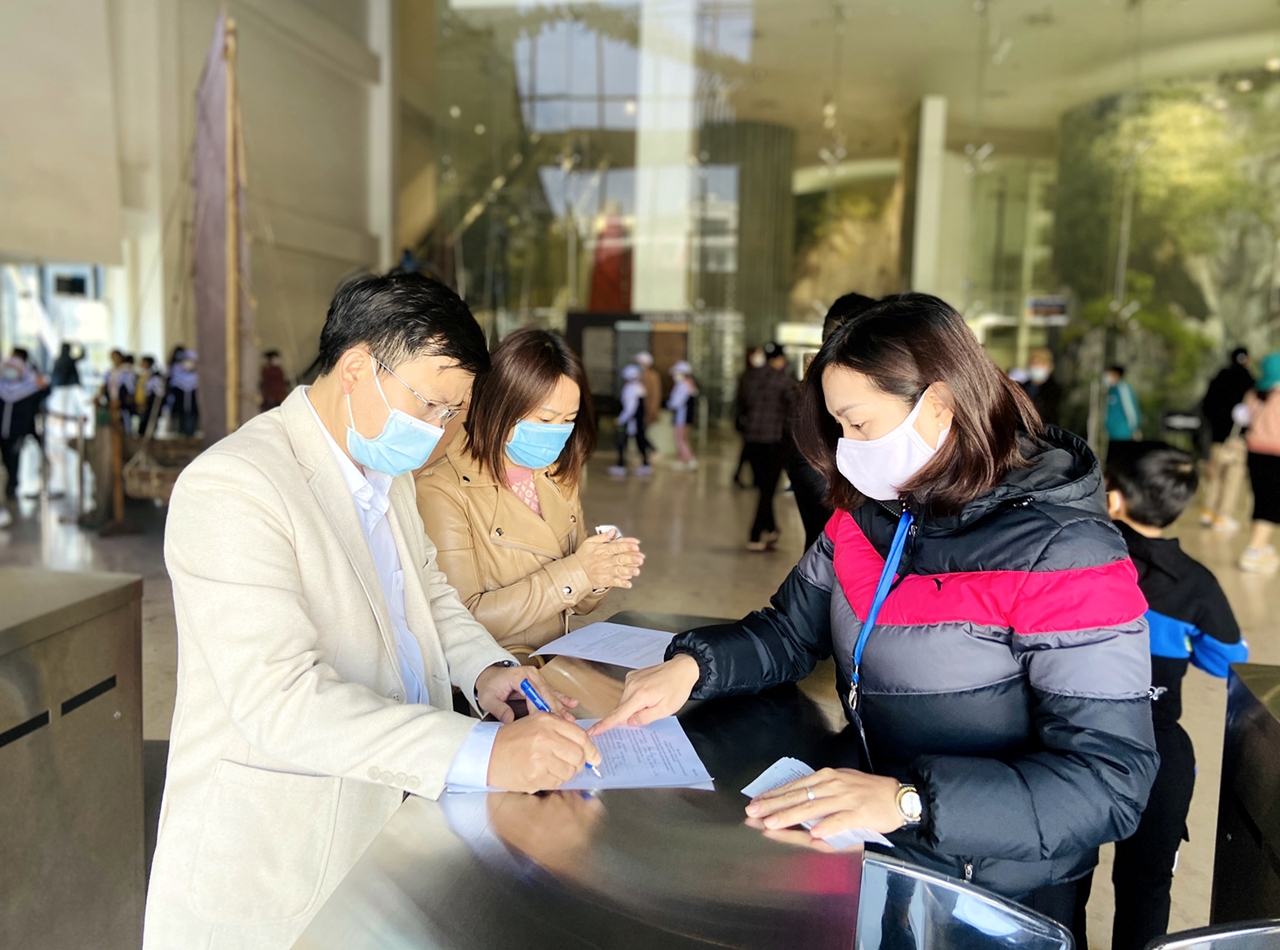 Nhân viên Bảo tàng Quảng Ninh hướng dẫn du khách khai báo y tế trước khi vào tham quan.