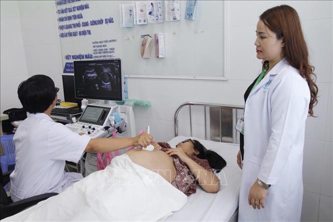 ác sỹ thực hiện siêu âm thai tại Trạm y tế phường Thảo Điền, Quận 2, TP Hồ Chí Minh. Ảnh: Đinh Hằng/TTXVN