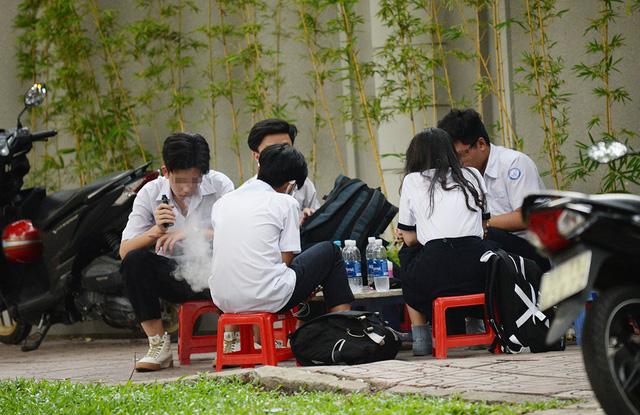 Học sinh tụ tập hút thuốc trên đường phố. Ảnh: Tuổi trẻ