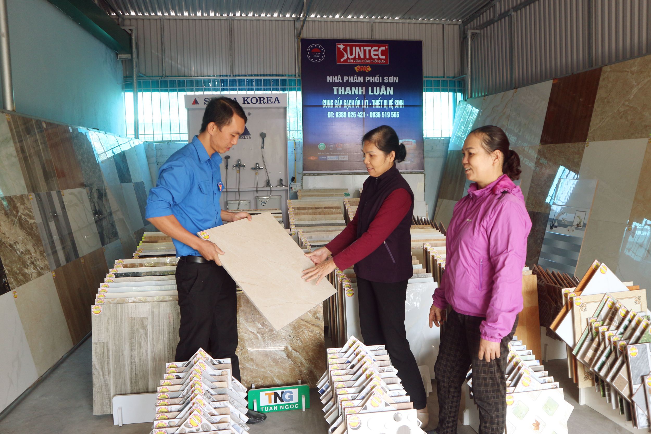 Hoàng Văn Luân (phường Yên Thanh, TP Uông Bí) đang giới thiệu các sản phẩm gạch ốp lát cho khách hàng.