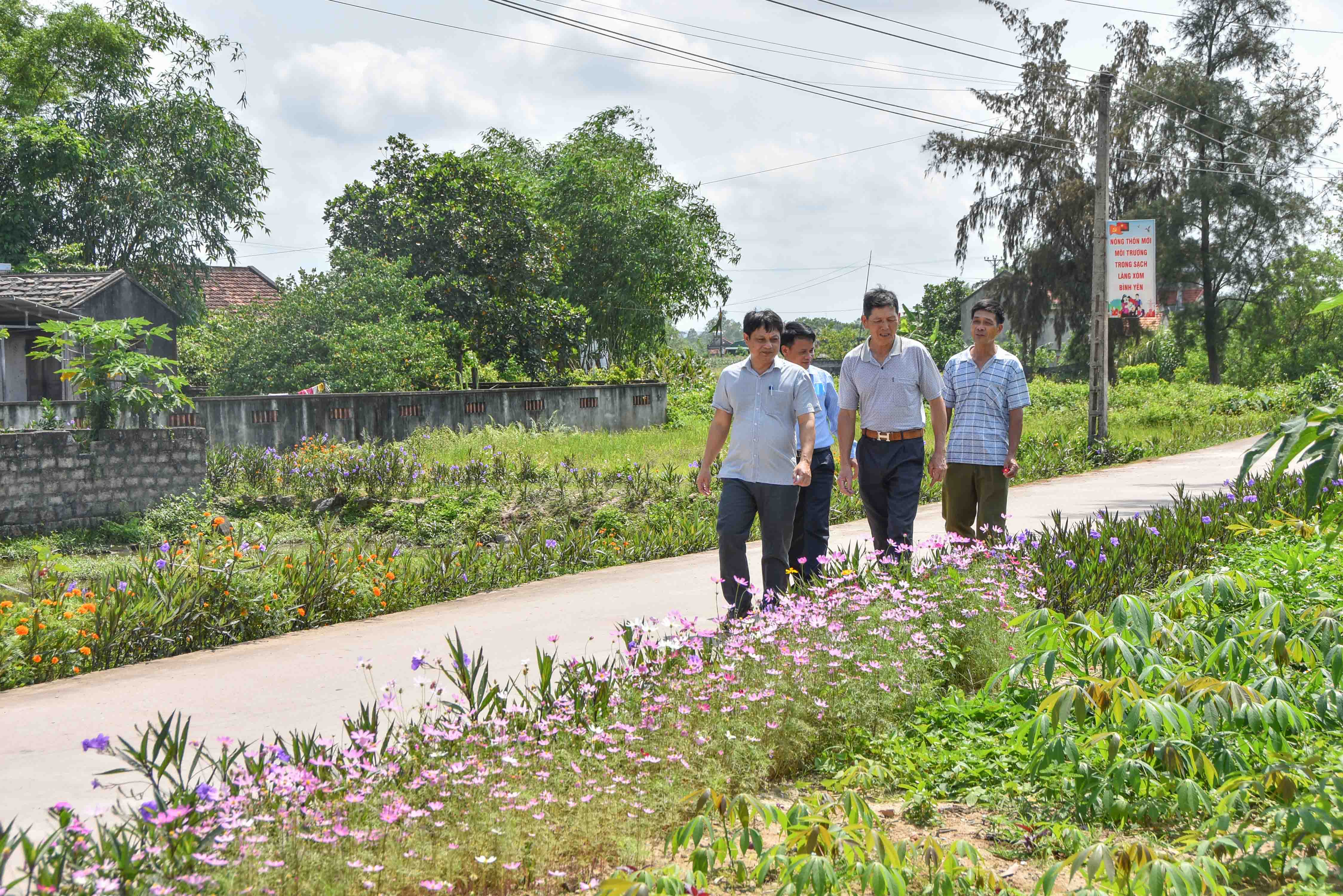 Cán bộ xã Hải Đông (TP Móng Cái) khảo sát việc chăm sóc tuyến đường hoa nông thôn mới tại thôn 3 của xã.