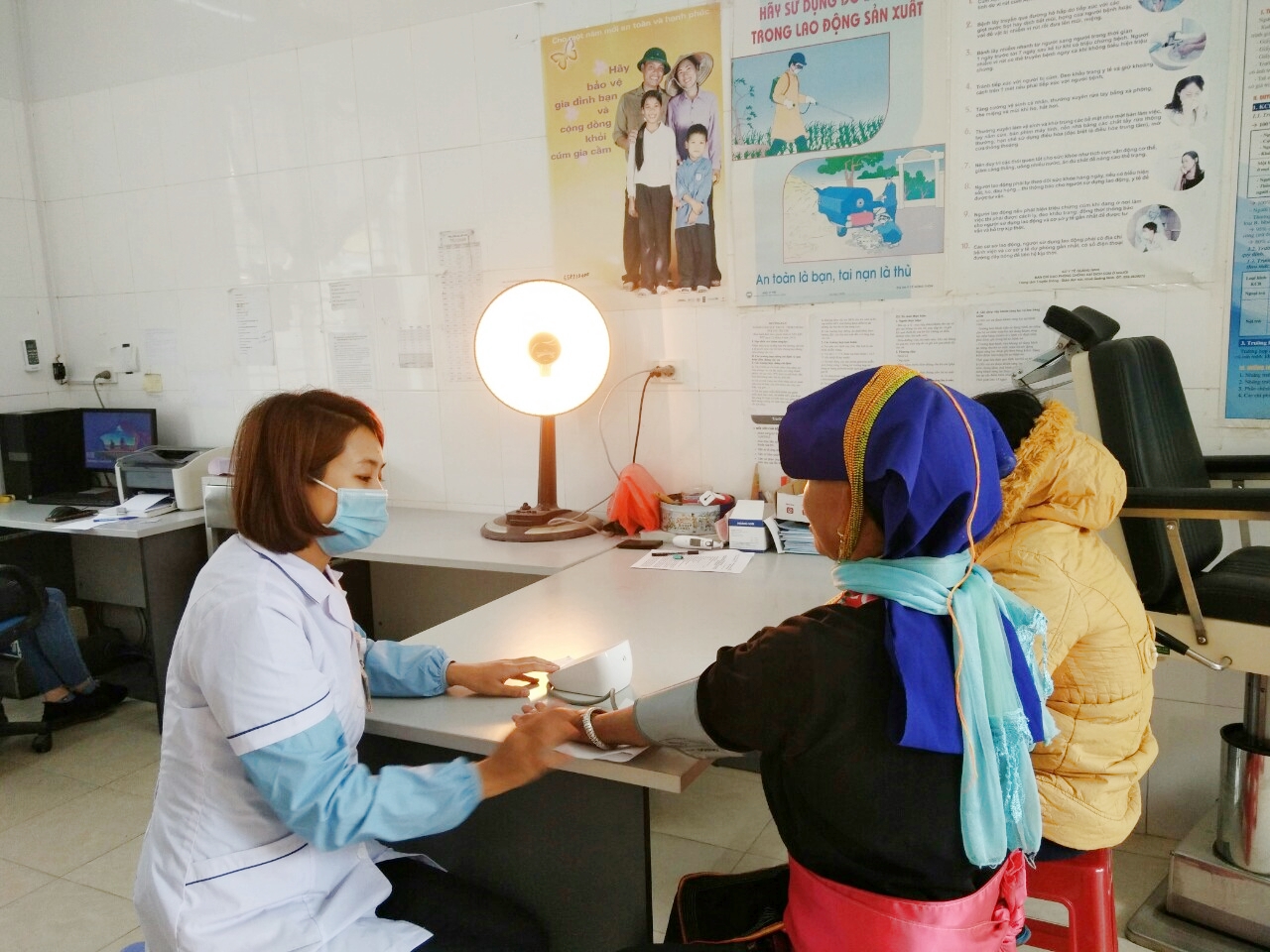 Nhân viên y tế Trạm y tế xã Đồn Đạc, huyện Ba Chẽ đang đo huyết áp cho người bệnh.