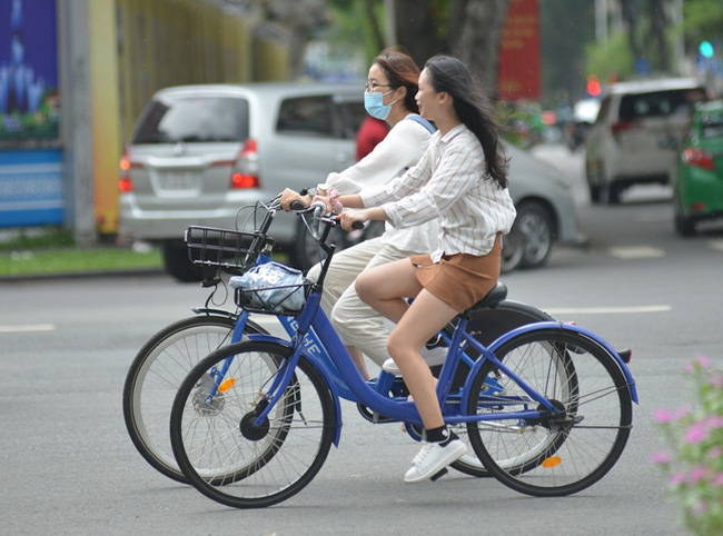 Các bạn trẻ thích thú trải nghiệm xe đạp công cộng tại trung tâm thành phố. (Ảnh: TTXVN)