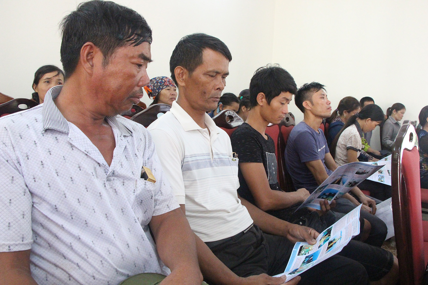 Ngư dân xã Tân An, TX Quảng Yên nghiên cứu tờ gấp tuyên truyền các quy định trong đánh bắt, nuôi trồng thúy sản.