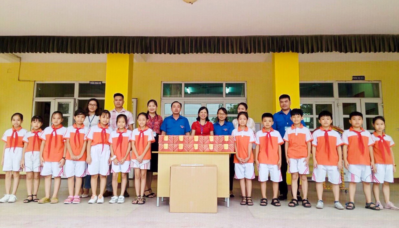 Anh Nguyễn Tuấn Anh (giữa) cùng ĐVTN phường tặng quà Trung thu 2020 cho học sinh Trường Tiểu học Võ Thị Sáu (phường Cẩm Phú).
