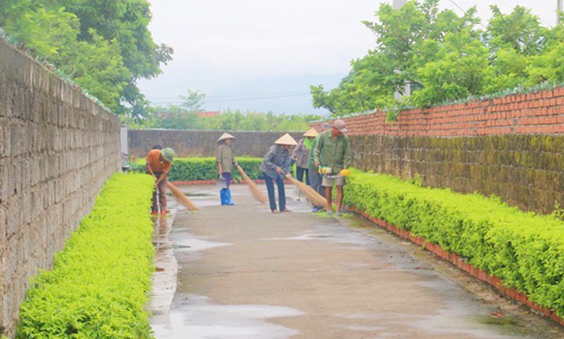 Người dân xã Việt Dân tham gia dọn vệ sinh môi trường tuyến đường kiểu mẫu trong xã.