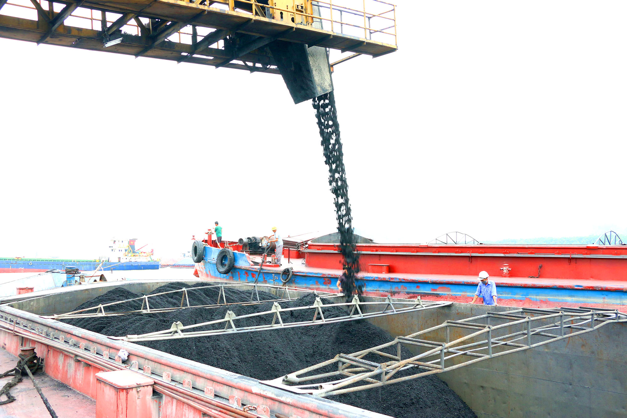 Năm 2021, Tập đoàn Công nghiệp Than - Khoáng sản Việt Nam phấn đấu tiêu thụ 42 triệu tấn than. Trong ảnh: Hoạt động bốc rót than tiêu thụ tại cảng Điền Công (Công ty Kho vận Đá Bạc).