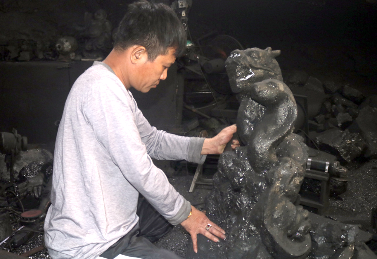 Anh Nguyễn Tiến Quyết, chủ nhân Xưởng chế tác than đá mỹ nghệ Quyết Bình (TP Hạ Long) thực hiện tác phẩm điêu khắc than đá. Ảnh: Nguyên Ngọc