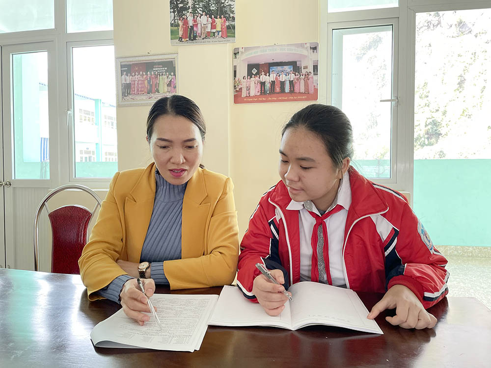 Cô giáo Đinh Thị Huệ, giáo viên chủ nhiệm hướng dẫn em Nguyễn Ngọc Phương Mai, lớp 9A5, Trường THCS Trần Quốc Toản làm bài tập. 