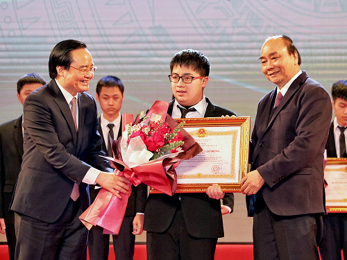Thủ tướng Nguyễn Xuân Phúc (phải) và Bộ trưởng GD&ĐT Phùng Xuân Nhạ (trái) trao tặng Huân chương Lao động hạng Nhì cho em Ngô Quý Đăng (giữa) với thành tích huy chương Vàng tại kỳ thi Olympic Toán quốc tế 2020.