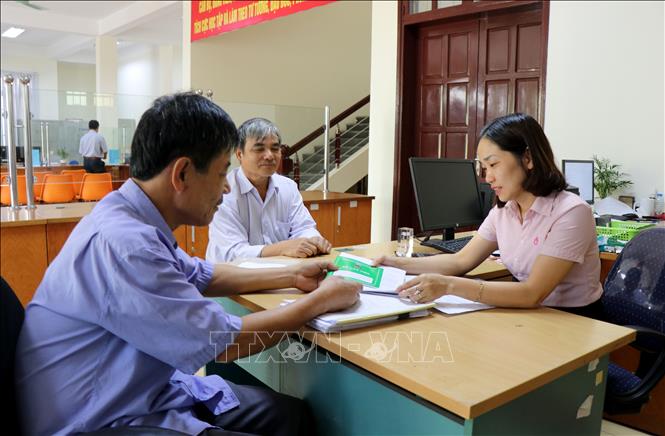 Cán bộ Ngân hàng Chính sách Xã hội tỉnh Bắc Ninh hướng dẫn người dân thủ tục vay vốn. Ảnh: Đinh Văn Nhiều/TTXVN