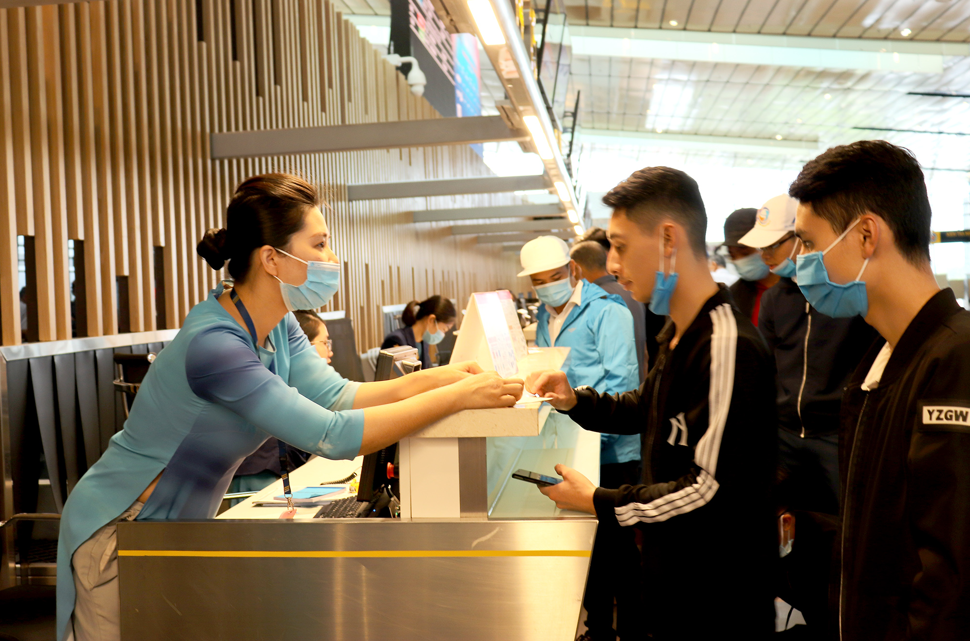Nhân viên tại Cảng hàng không quốc tế Vân Đồn hướng dân người dân làm thủ tục lên máy bay. 