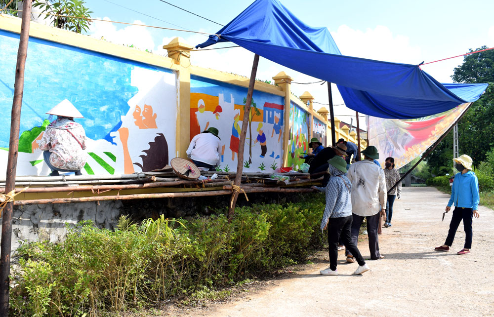 Các hội viên Chi hội VHNT xã Đông Ngũ vẽ tranh tường tại thôn Đông Thắng, xã Đông Ngũ làm đẹp đường làng, ngõ xóm.