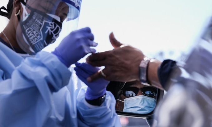 Nhân viên y tế lấy mẫu xét nghiệm Covid-19 cho một tài xế tại bang California, Mỹ hôm 18/1. Ảnh: AFP.
