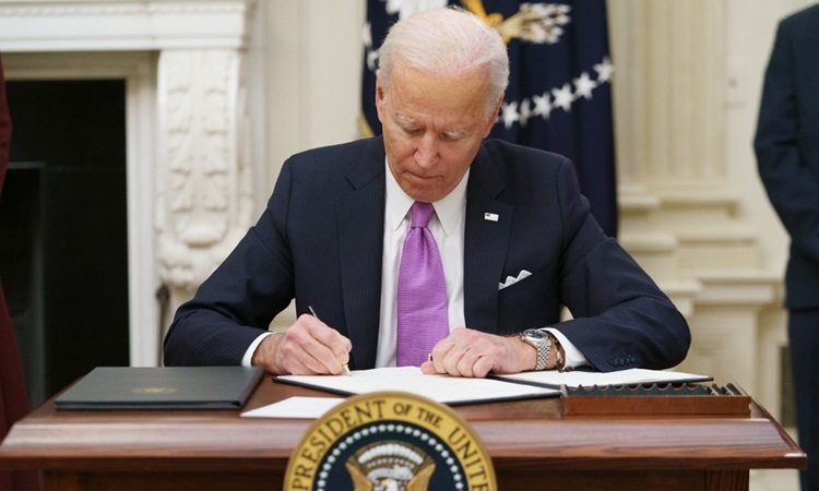 Tổng thống Mỹ Joe Biden ký sắc lệnh Covid-19 tại Nhà Trắng hôm 21/1. Ảnh: AFP.