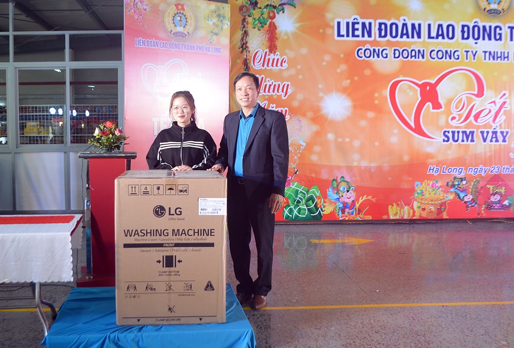 Ông Phạm Ngọc Hưng, Chủ tịch LĐLĐ TP Hạ Long trao chiếc phần quà giá trị là chiêc máy giặt cho công nhân may mắn trúng thưởng.