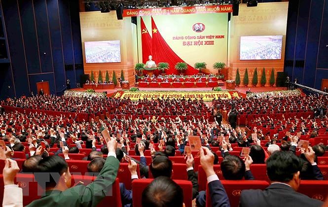 Các đại biểu biểu quyết, thông qua Nghị quyết Đại hội XIII Đảng Cộng sản Việt Nam. (Nguồn: TTXVN)