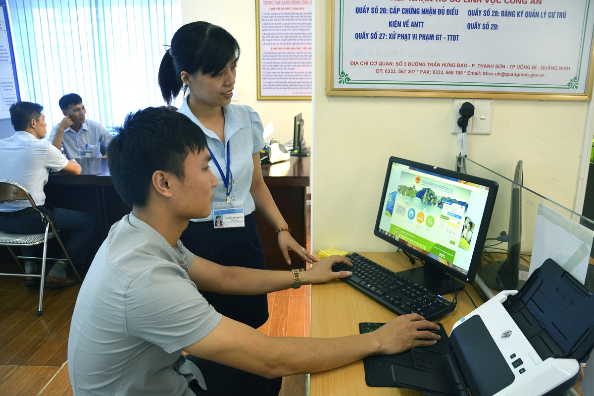 Cán bộ Trung tâm Hành chính công TP Uông Bí hướng dẫn người dân kê khai hồ sơ qua hệ thống website