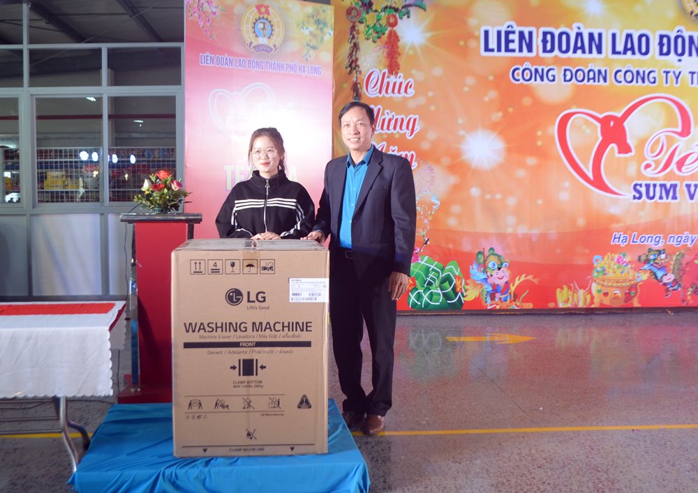 Ông Phạm Ngọc Hưng, Chủ tịch LĐLĐ TP Hạ Long, trao chiếc máy giặt trị giá 7,5 triệu đồng cho công nhân may mắn trúng thưởng.