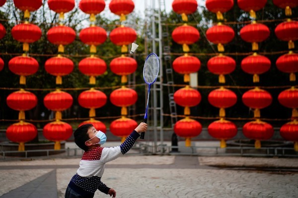  Cậu bé chơi cầu lông tại một con phố được trang trí đèn lồng Tết ở Vũ Hán, Trung Quốc hôm 8/2. Ảnh: Reuters
