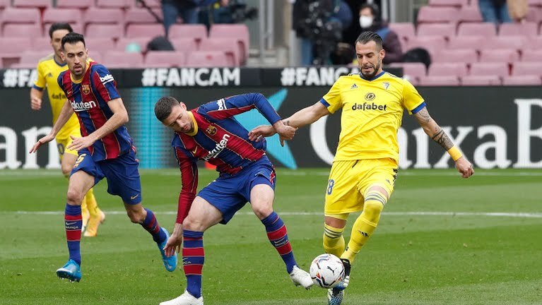 Lenglet (giữa) nỗ lực ngăn chặn pha xuống bóng của cầu thủ Cadiz. Ảnh: Reuters.