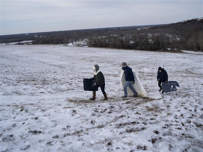 Người dân di chuyển trên đồi phủ đầy tuyết trắng ở Waco, bang Texas, Mỹ ngày 18/2. Ảnh: AFP/TTXVN