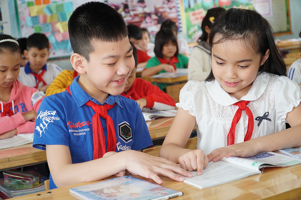 Dù bị khuyết tật nhưng Nguyễn Đăng Khôi (bên trái), Trường Tiểu học Trưng Vương (TP Uông Bí) vẫn rất nỗ lực, đạt thành tích cao trong học tập, được bạn bè yêu mến.