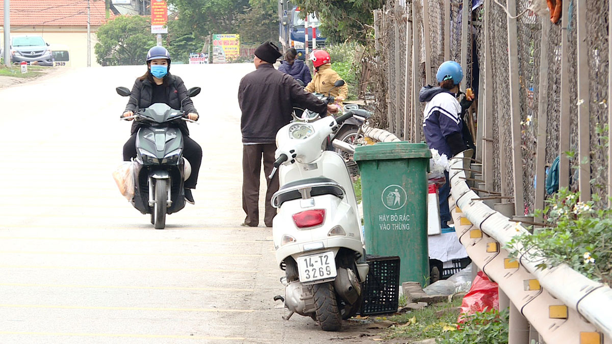 Nhiều người dân do tiện lợi vẫn vạch hàng rào chắn, đi ngược chiều bất chấp nguy hiểm để mua bán tại chợ Long Bình, xã Quảng Long, huyện Hải Hà. Ảnh chụp ngày 10/3. 