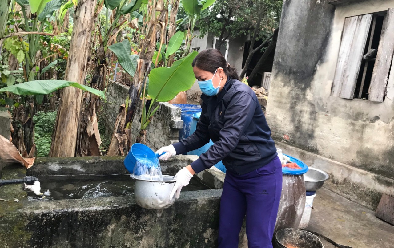 Bà Đinh Thị Chung, thôn 16, xã Hiệp Hòa phấn khởi khi được dùng nước sạch. 