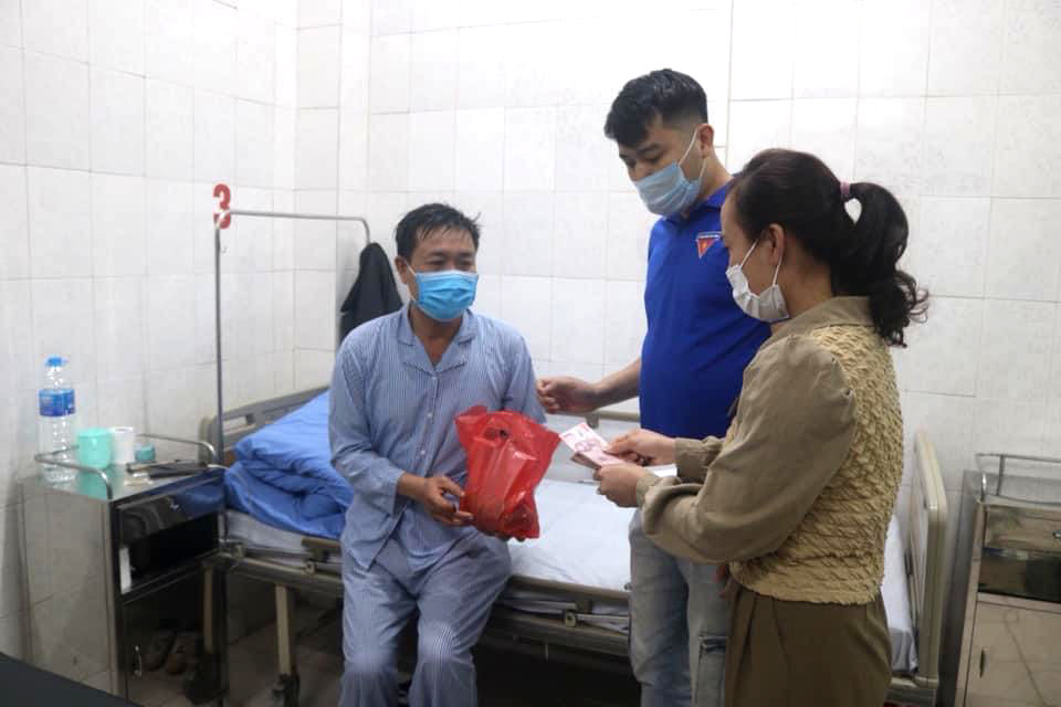 Nguyễn Vũ Long cùng đồng nghiệp cơ quan tặng quà cho một bệnh nhân có hoàn cảnh khó khăn điều trị tại Trung tâm Y tế Tiên Yên.