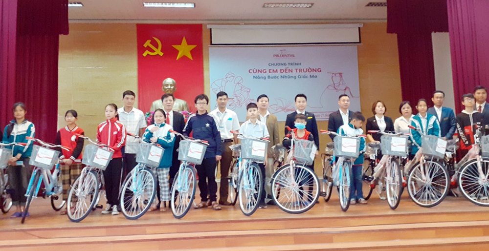 Đại diện Công ty BHNT Prudential Việt Nam và Hội CTĐ trao xe đạp cho học sinh nghèo vượt khó tại TP Uông Bí cuối tháng 8/2019.