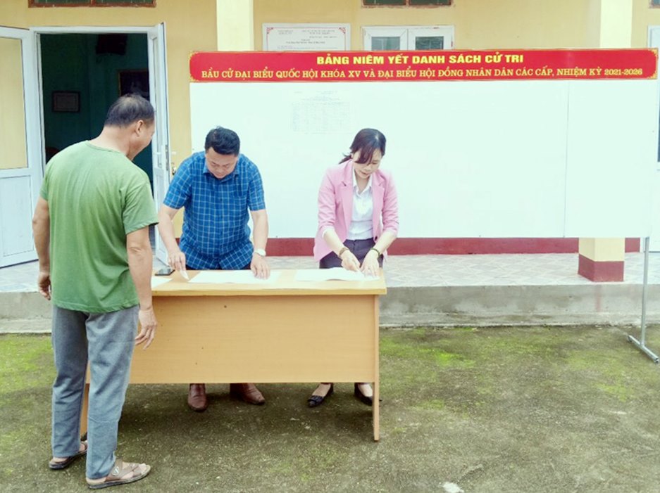 Cán bộ HND xã Quảng Tân (huyện Đầm Hà) niêm yết danh sách cử tri tại Tổ bầu cử thôn Thanh Sơn.