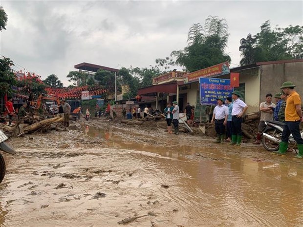 Bùn đất theo lũ trôi về tràn ngập trên Quốc lộ 279. (Ảnh Hồng Ninh/TTXVN)