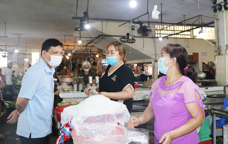 Bí thư Thành ủy Uông Bí Nghiên Xuân Cường truyên truyền cho tiểu thương chợ Thanh Sơn, TP Uông Bí về nguy cơ lây lan bệnh dịch Covid -19.