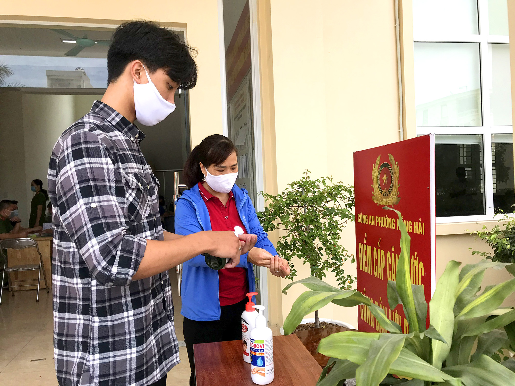 Người dân sát khuẩn tay trước khi làm thủ tục cấp CCCD tại phường Hồng Hải (TP Hạ Long)