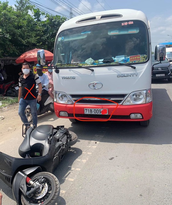  Chiếc xe khách chạy vào làn đường cho xe hai bánh, tông vào xe máy của người phản đối và người áo đen trong hình, còn đánh người đi đường - Ảnh: M.T.