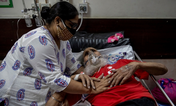 Người thân chăm sóc cho một bệnh nhân Covid-19 ở New Delhi ngày 1/5. Ảnh: Reuters.
