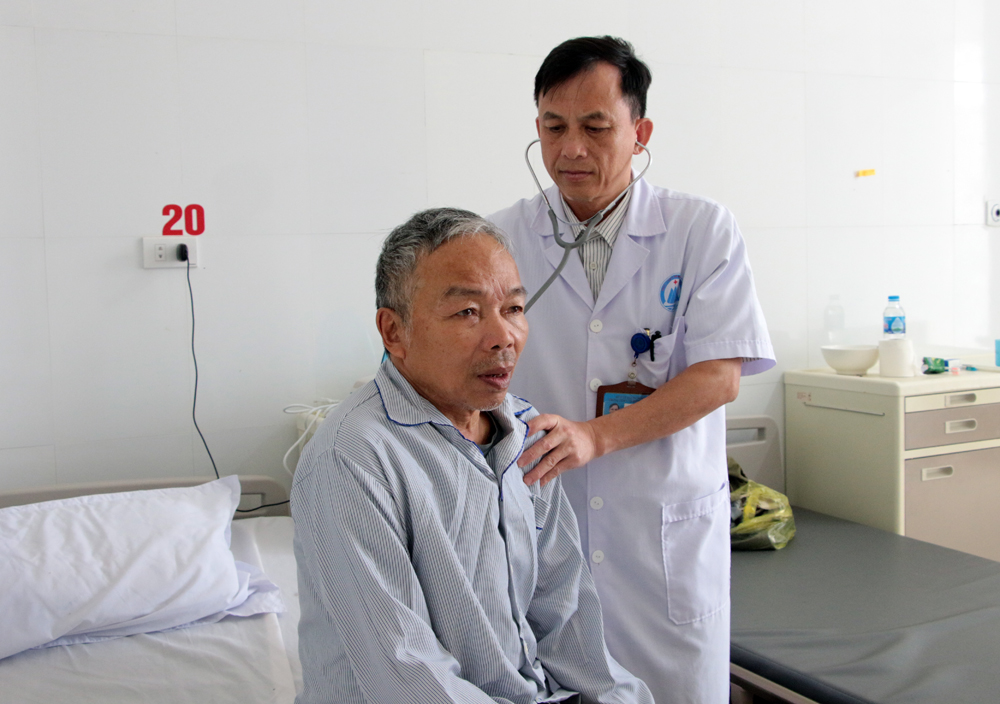 Bác sĩ Nguyễn Thanh Giang kiểm tra sức khỏe cho bệnh nhân điều trị nội trú tại Trung tâm Y tế huyện Cô Tô.